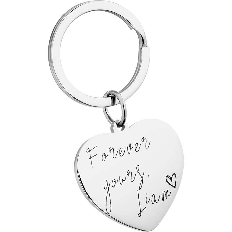 Porte clé personnalisé en forme de cœur en acier inoxydable argent avec message manuscrit gravé et anneau métallique.